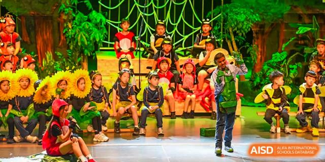 Students from Yew Wah International Education School of Zhejiang Tongxiang performing on stage in bright costumes.