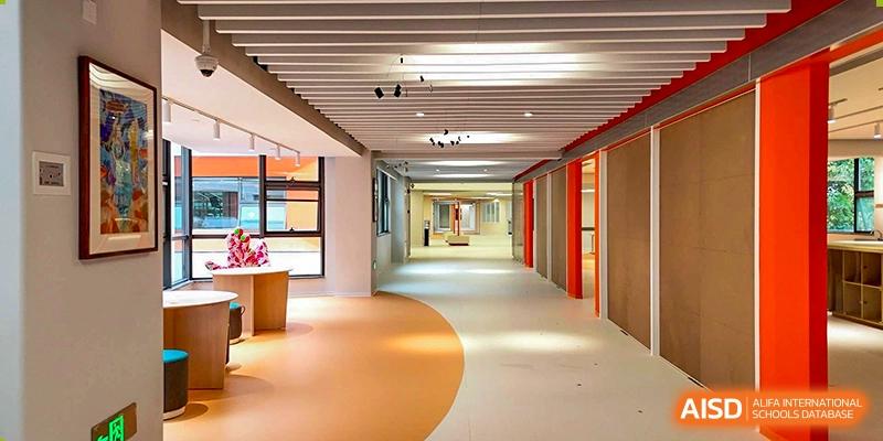 An interior view of a modern, brightly lit hallway and common area at Yew Wah International Education School of Zhejiang Tongxiang.