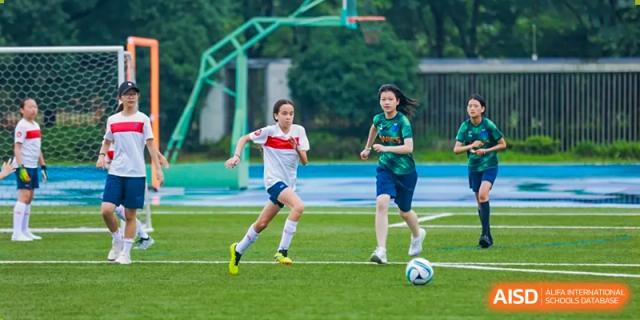 Students from Yew Wah International Education School of Zhejiang Tongxiang playing soccer on an outdoor field.