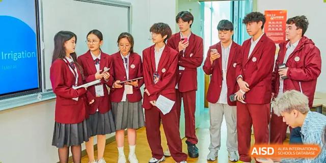 A group of students in red and white uniforms posing formally, with one student standing out in the front at Zibo MacDuffie Bilingual High School.