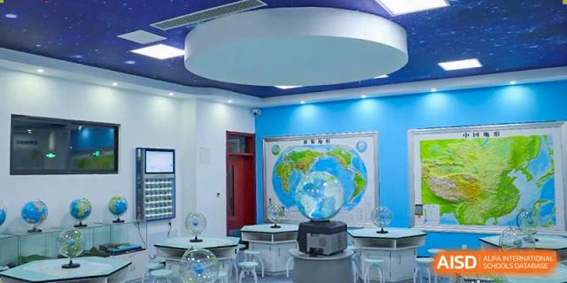 A dedicated geography or global studies classroom featuring a world map mural and a globe at Zibo MacDuffie Bilingual High School.
