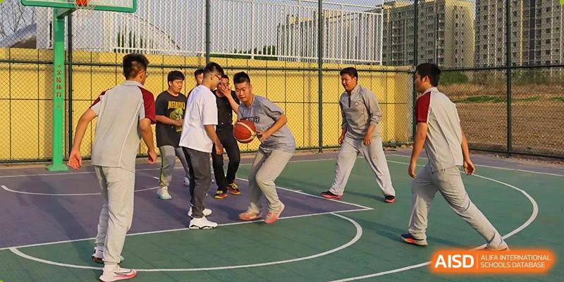 Students playing basketball on an outdoor court at Zibo MacDuffie Bilingual High School.