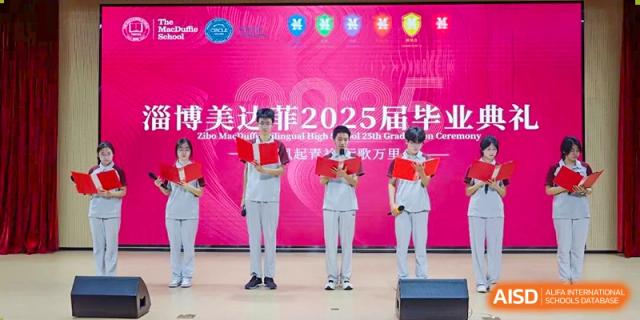 A stage performance with students holding cards or awards during a school ceremony at Zibo MacDuffie Bilingual High School.