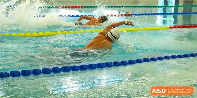 A student swimming the freestyle stroke in an indoor pool at Zibo MacDuffie Bilingual High School.