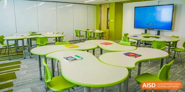 A bright, modern classroom or dining area with green and white furniture at Yew Wah International Education School of Yantai Campus.