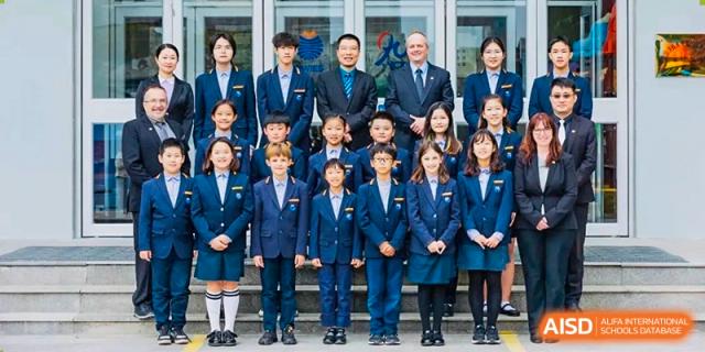 Group photo of Yew Wah International Education School of Yantai Campus students in uniform with teachers and administrators.