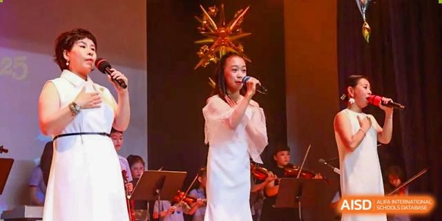 A young YewWah International Education School of Yantai Campus student singing on a stage with an orchestra.