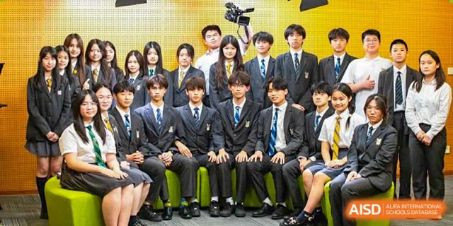 A group of male students in formal school blazers sitting closely together for a group photo or event at Sedbergh School Fuzhou.