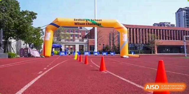 An inflatable yellow archway over a red running track marking the start of the "Wilson Challenge" event at Sedbergh School Fuzhou.