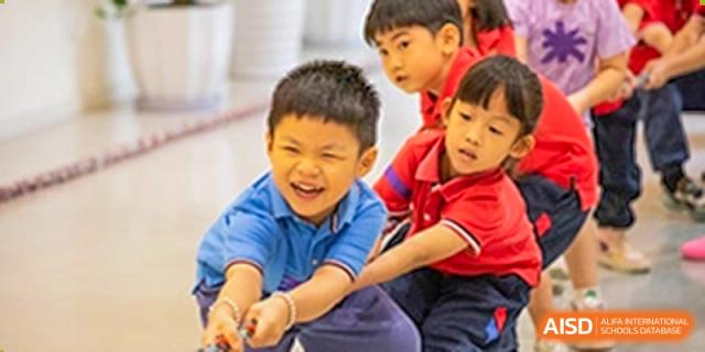 Enthusiastic young students pulling hard during a tug-of-war competition at a school sports event at Sedbergh School Fuzhou.