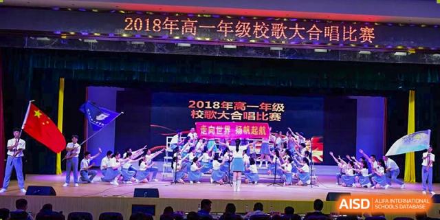 Wenzhou No.22 Senior Middle School choir or performance group on stage under a banner for the "2018 Senior Grade Grand Choir Competition."