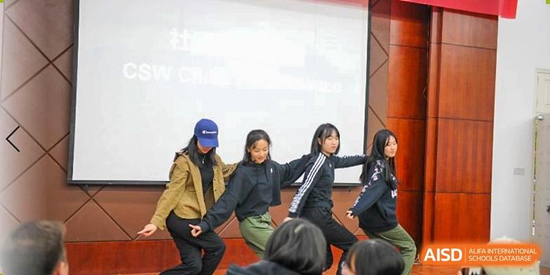 Wenzhou No.22 Senior Middle School students giving a group presentation or performance on stage in front of a large projection screen.