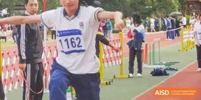 Wenzhou No.22 Senior Middle School student with a running bib number 1162 competing in an outdoor track and field hurdle event.