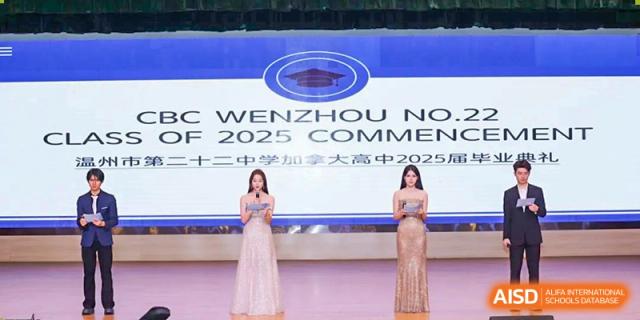 Two women in formal gowns standing on stage at a commencement or ceremony event for Wenzhou No.22 Senior Middle School, with a banner visible behind them.