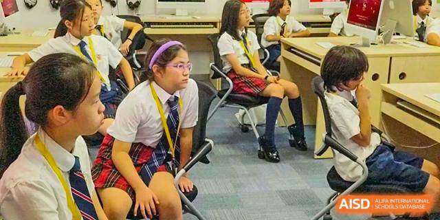 Female students from Dulwich International High School Programme Hengqin (DHHQ) sitting attentively in a classroom during a lesson or presentation.