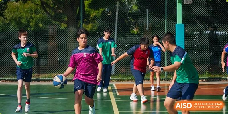Students from Dulwich International High School Programme Hengqin (DHHQ) participating in an outdoor team-building or physical education activity in their sports uniforms.