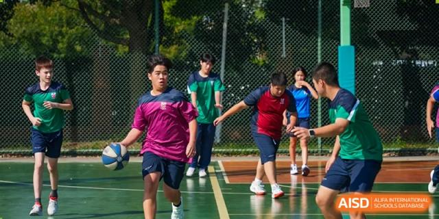 Students from Dulwich International High School Programme Hengqin (DHHQ) participating in an outdoor team-building or physical education activity in their sports uniforms.