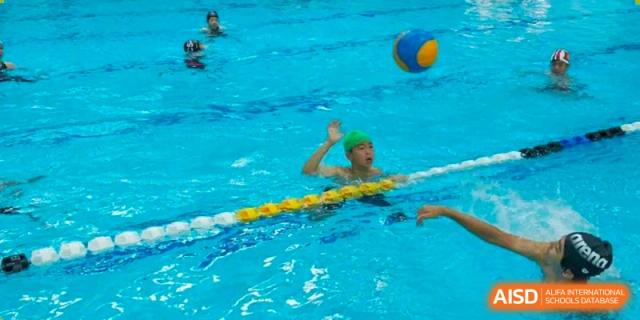 A student from Dulwich International High School Programme Hengqin (DHHQ) swimming during a practice session, with a yellow lane divider visible.