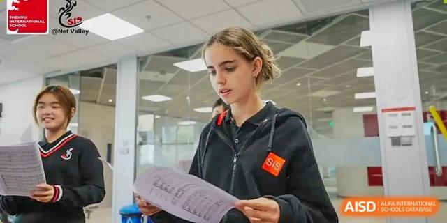 A high school student reading notes and concentrating during a class session at Shekou International School.
