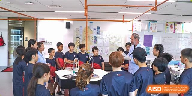A group of students conducting a hands-on chemistry experiment in a science lab at Shekou International School.