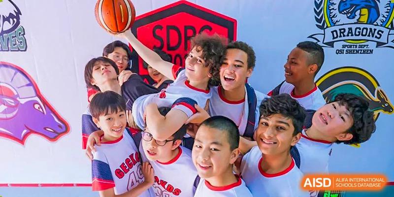 A group of diverse students at Shekou International School celebrating together after a basketball game, showcasing strong friendship and team spirit.