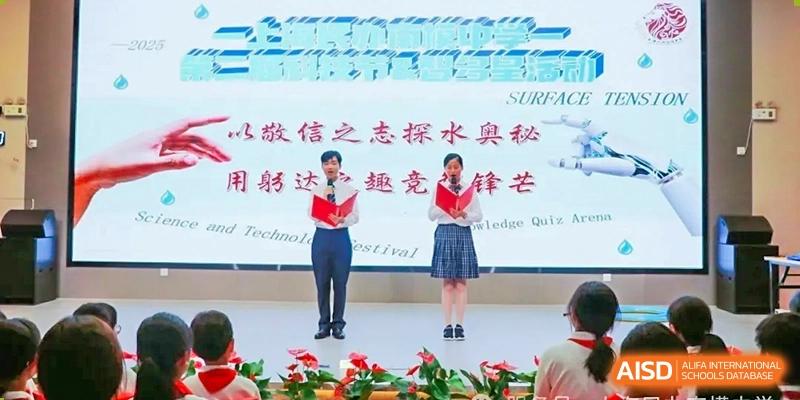 Two students in uniform presenting or hosting an event on an outdoor stage at Shanghai Nanyang Model Private School.