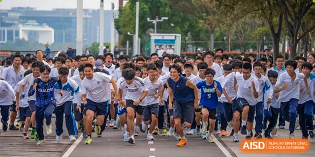 A group of students starting a running race outdoors during a sports day event at Shanghai Nanyang Model Private School.