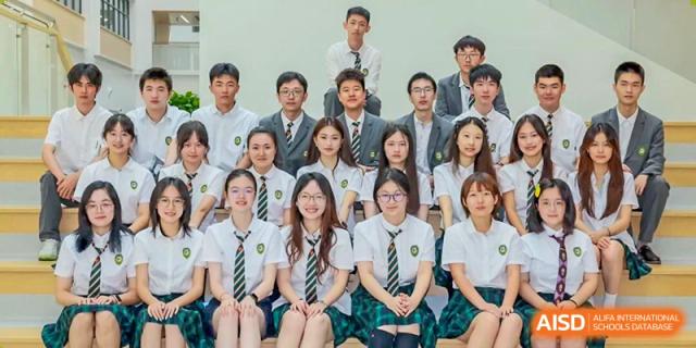 A class portrait of Shanghai Pinghe School high school students in uniform, seated with several teachers standing behind them.