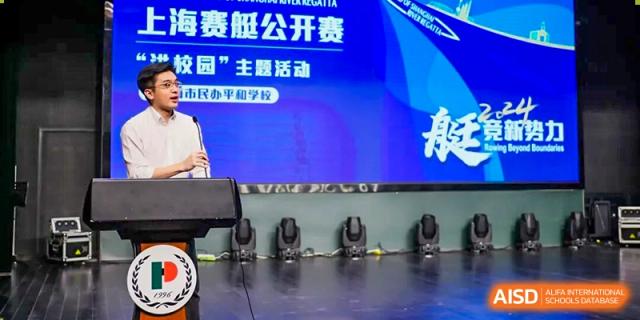 A stage setup with a large screen displaying Chinese text, including "校园" (campus/school) and "上海市民办平和学校" (Shanghai Pinghe School), possibly for a competition or event.