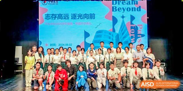 A group of students and teachers smiling and posing for a group photo in front of a banner that reads "Dream Beyond" at Shanghai Pinghe School.