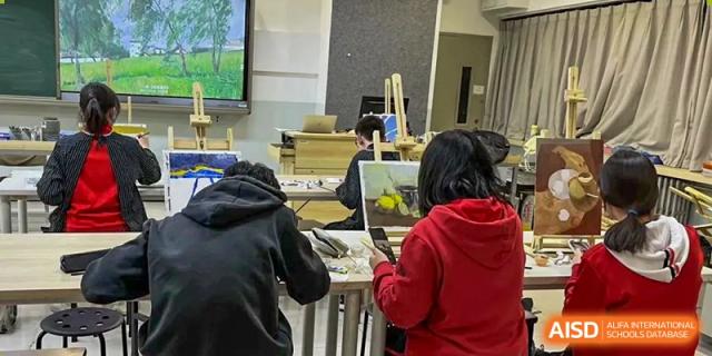 Chengdu Experimental Foreign Languages School International Department students working collaboratively on laptops and tables in a classroom setting.