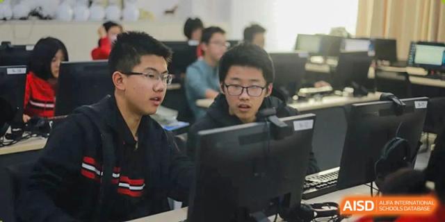 Close-up of Chengdu Experimental Foreign Languages School International Department students working side-by-side on desktop computers in a lab or classroom.