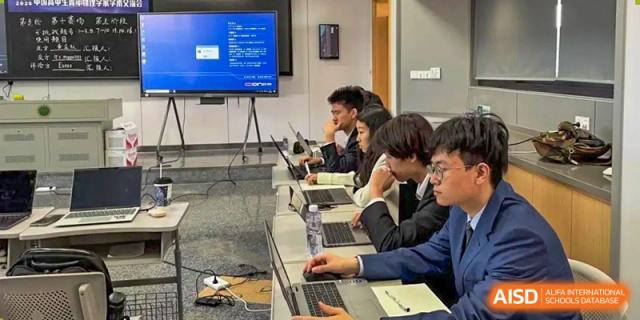 Chengdu Experimental Foreign Languages School International Department students working on laptops and viewing data on a large display screen in a modern learning environment.
