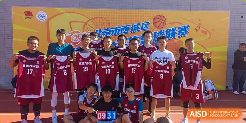 Chengdu Experimental Foreign Languages School International Department basketball team posing for a group photo outdoors, wearing red and white jerseys, with a banner behind them.