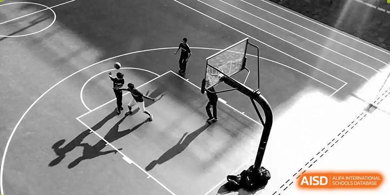 Chengdu Experimental Foreign Languages School International Department students playing an intense game of 3x3 basketball on an outdoor court, captured in black and white.