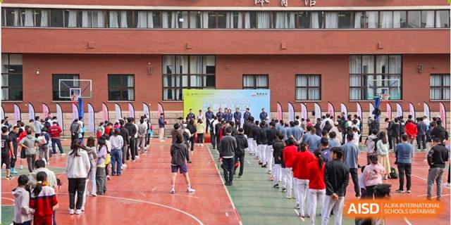 Students from Chengdu Experimental Foreign Languages School International Department marching or walking in a formal line outside a campus building, possibly for an event or ceremony.