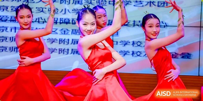 A close-up shot of a student from Chengdu Experimental Foreign Languages School International Department performing a dance in a bright red costume on stage.