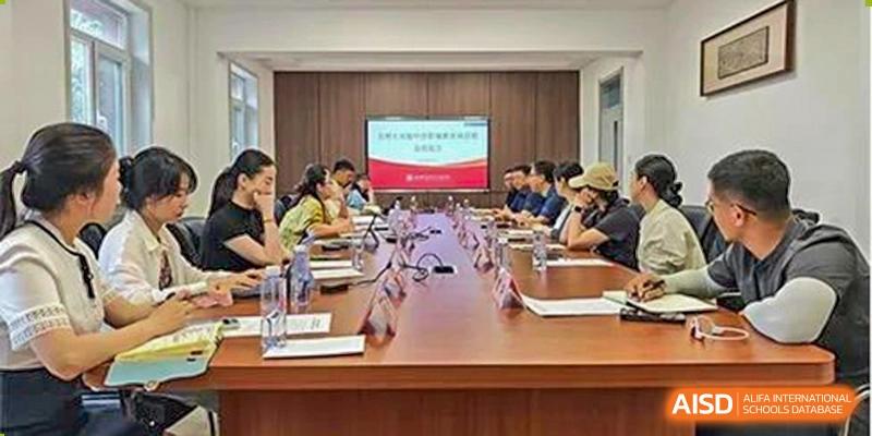 A group of teachers or staff from Chengdu Experimental Foreign Languages School International Department seated around a conference table in a meeting room for a discussion.