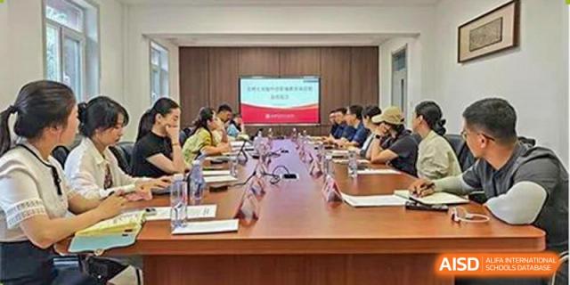 A group of teachers or staff from Chengdu Experimental Foreign Languages School International Department seated around a conference table in a meeting room for a discussion.