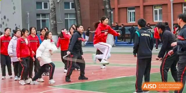 Chengdu Experimental Foreign Languages School International Department students participating in jump rope or other outdoor athletic activities on a court.