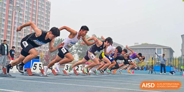 Chengdu Experimental Foreign Languages School International Department students exploding off the starting blocks at the beginning of a sprint race on a track.