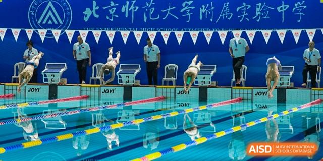 Chengdu Experimental Foreign Languages School International Department swimming competition in progress, showing a starting block and lane markers in a bright blue pool.
