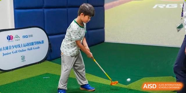 A young boy practicing his swing in an indoor golf facility at Shanghai Hongqiao International School.