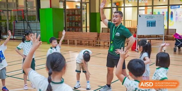 Students engaging in a sports activity or game indoors on a gymnasium floor at Shanghai Hongqiao International School.