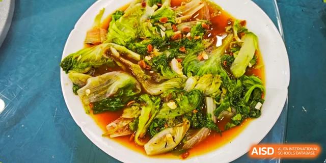 A close-up photo of a prepared stir-fried vegetable dish at Shanghai Hongqiao International School.