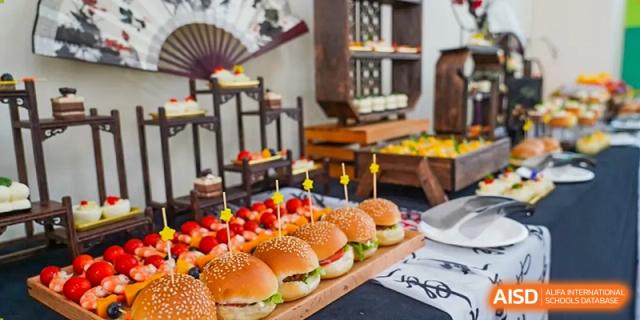A beautiful catering display featuring rows of mini hamburgers or sliders, likely for a school event at Shanghai Hongqiao International School.