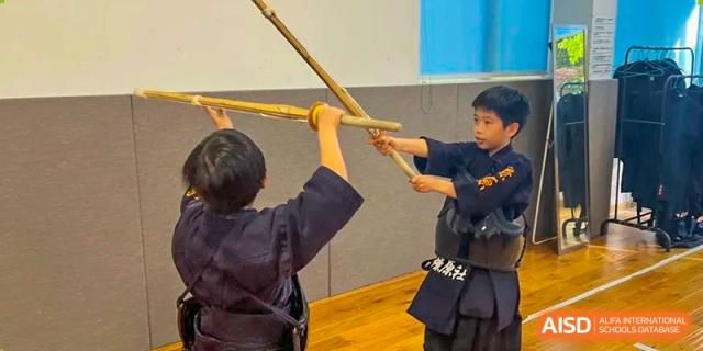 Students practicing a martial arts class with wooden swords, possibly Kendo, at Shanghai Liaoyuan Bilingual School.
