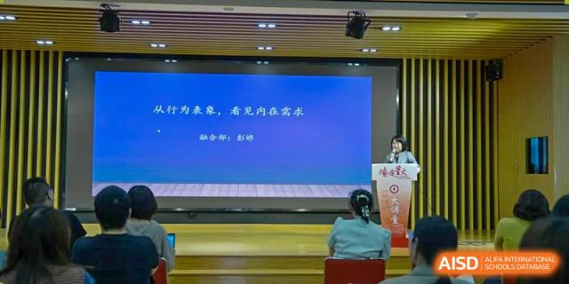 A large screen displaying Chinese text during a lecture or presentation to an audience at Shanghai Liaoyuan Bilingual School.