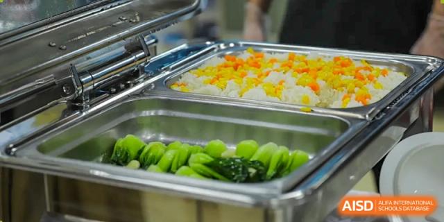 A buffet tray of brightly colored, perfectly steamed or stir-fried green vegetables, part of the nutritious options at QSI International School of Shenzhen.