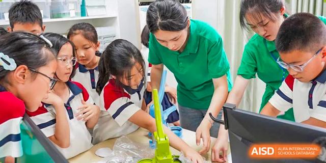 A teacher guiding two students during a science experiment or practical lesson involving liquid and lab tools at Suzhou Foreign Language School.